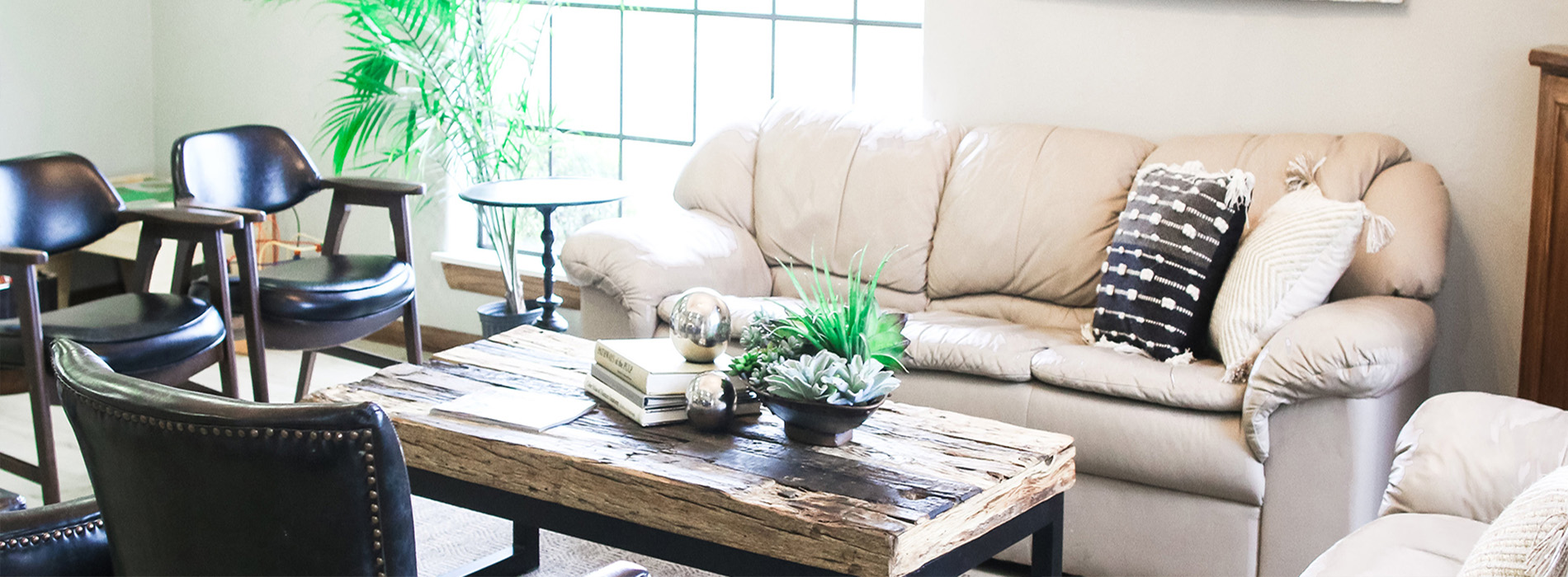 An interior photo of a modern living room with a neutral color palette featuring furniture and decorative items.