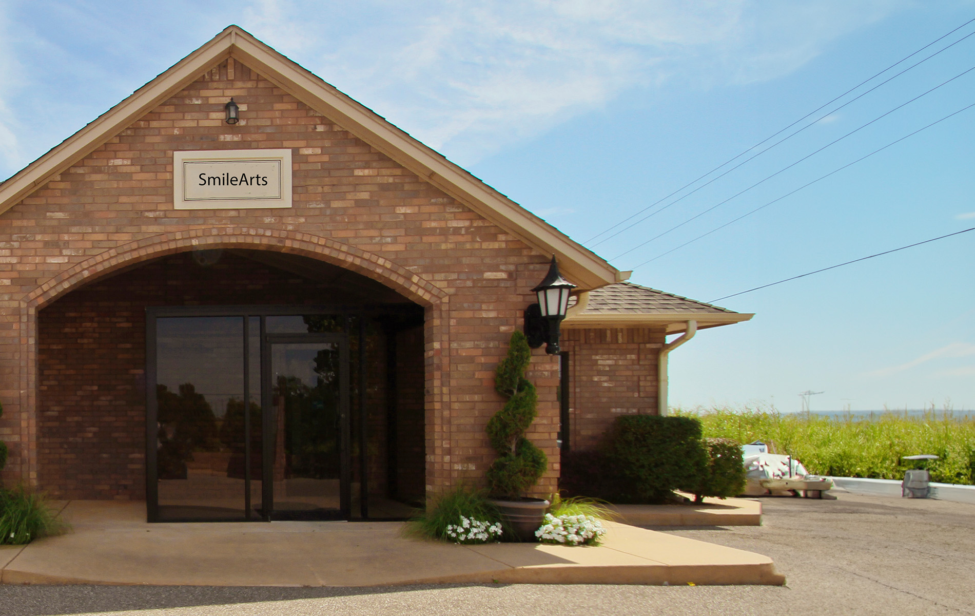 The image shows a brick building with a sign that reads  Smileworks  on its facade, under a clear sky.