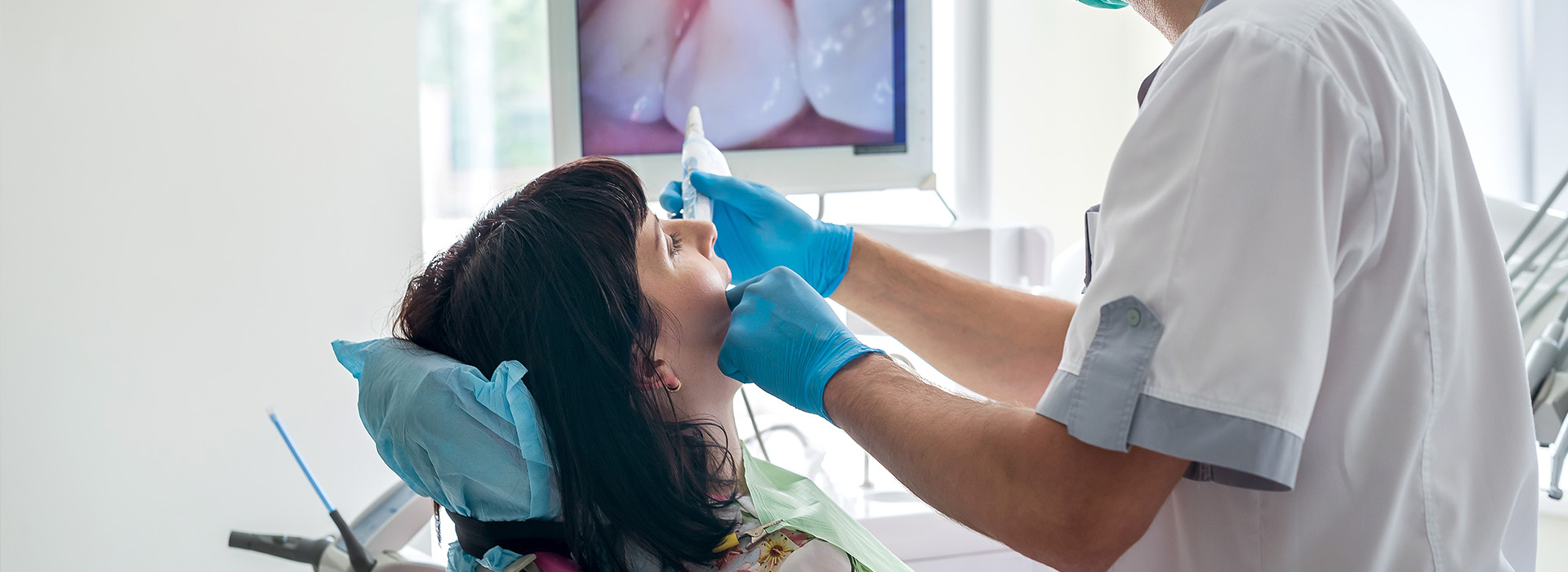 A dental professional performing a procedure on a patient s mouth using a dental chair and instruments.