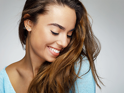 The image shows a woman with long hair smiling at the camera, captured from two different angles.