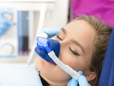 A person receiving medical care with an oxygen mask on their face while lying down.